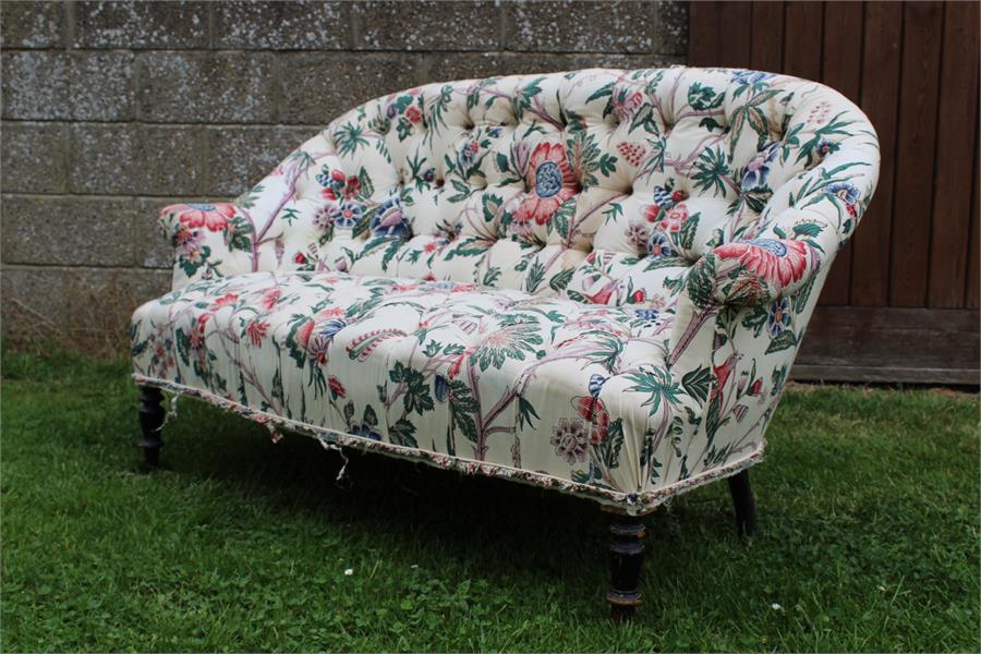 19th century buttoned sofa of small proportions supported on turned ebonised legs with metal