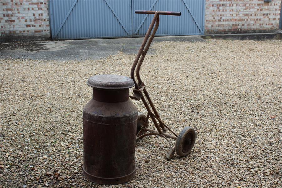 vintage metal milk churn with lid on a metal trolley