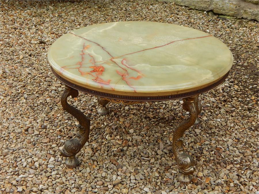 Onyx and brass coffee table on brass stylised fish supports. ~