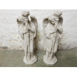 Two candle pricket stands in the form of winged angels in modern stone-effect resin.