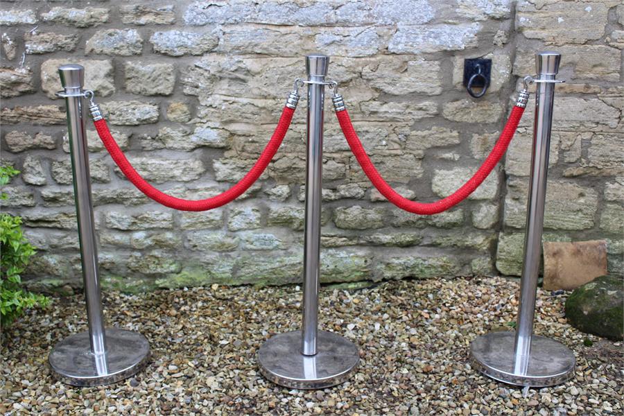 three Chrome barrier stands and two ropes