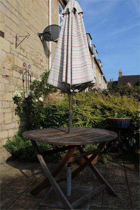 A teak garden table and parasol.