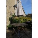 A teak garden table and parasol.