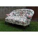 19th century buttoned sofa of small proportions supported on turned ebonised legs with metal