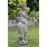 A nicely weathered composition garden statue of a robed classical female.