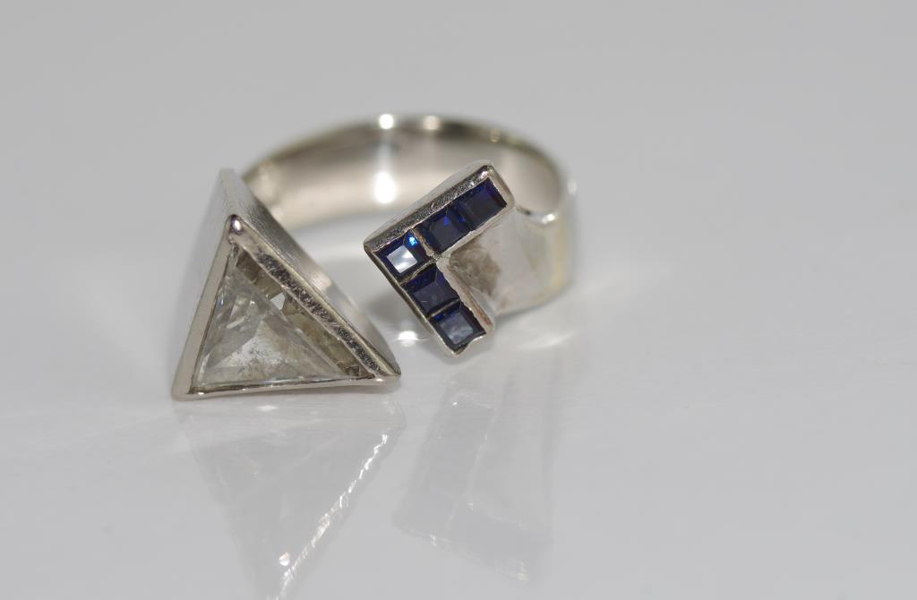 18ct white gold diamond and sapphire ring from De Beers,. Triangular diamond rub over set with 5