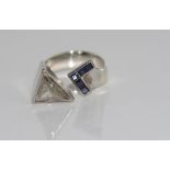 18ct white gold diamond and sapphire ring from De Beers,. Triangular diamond rub over set with 5