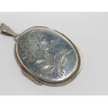Sterling silver oval locket with engraved floral decoration, marked Birmingham 1977