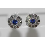 Pair of cluster diamond & sapphire earrings set in 18ct white gold, each has six diamonds around a