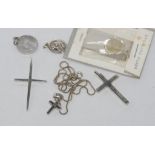 Four silver crosses one with silver chain together with other religious charms