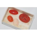 Three coral cabochons with a carved coral piece