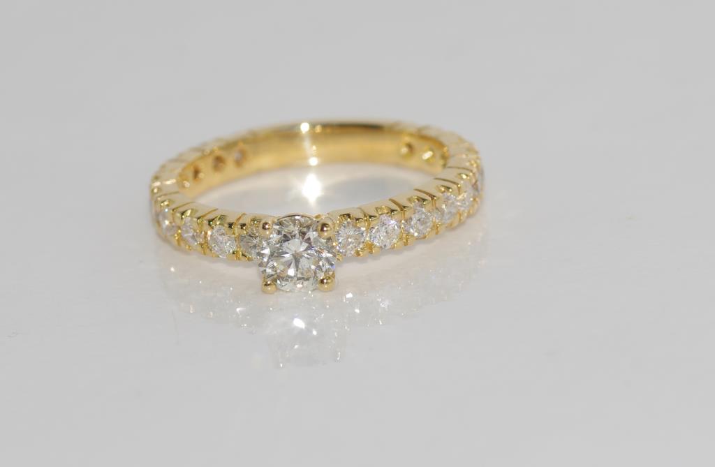 18ct yellow gold, diamond ring set with 0.57ct centre diamond H/Pq and 20 smaller diamonds TDW=0.