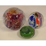 Three assorted glass paperweights two with signed bases, 11cm diameter (largest) approx.