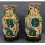 Two large Chinese porcelain vases with figural and foo dog decoration, on carved timber stands,