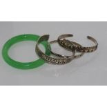 Mexican silver inlaid bangle with a cuff marked 925 together with an unmarked cuff and a green glass