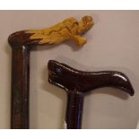 Two carved timber walking sticks to include one with a dragon head handle and the other a mythical