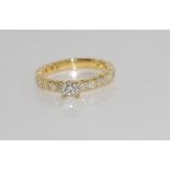 18ct yellow gold, diamond ring set with 0.57ct centre diamond H/Pq and 20 smaller diamonds TDW=0.