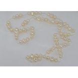 White pearl necklace with trios of pearls in various sizes