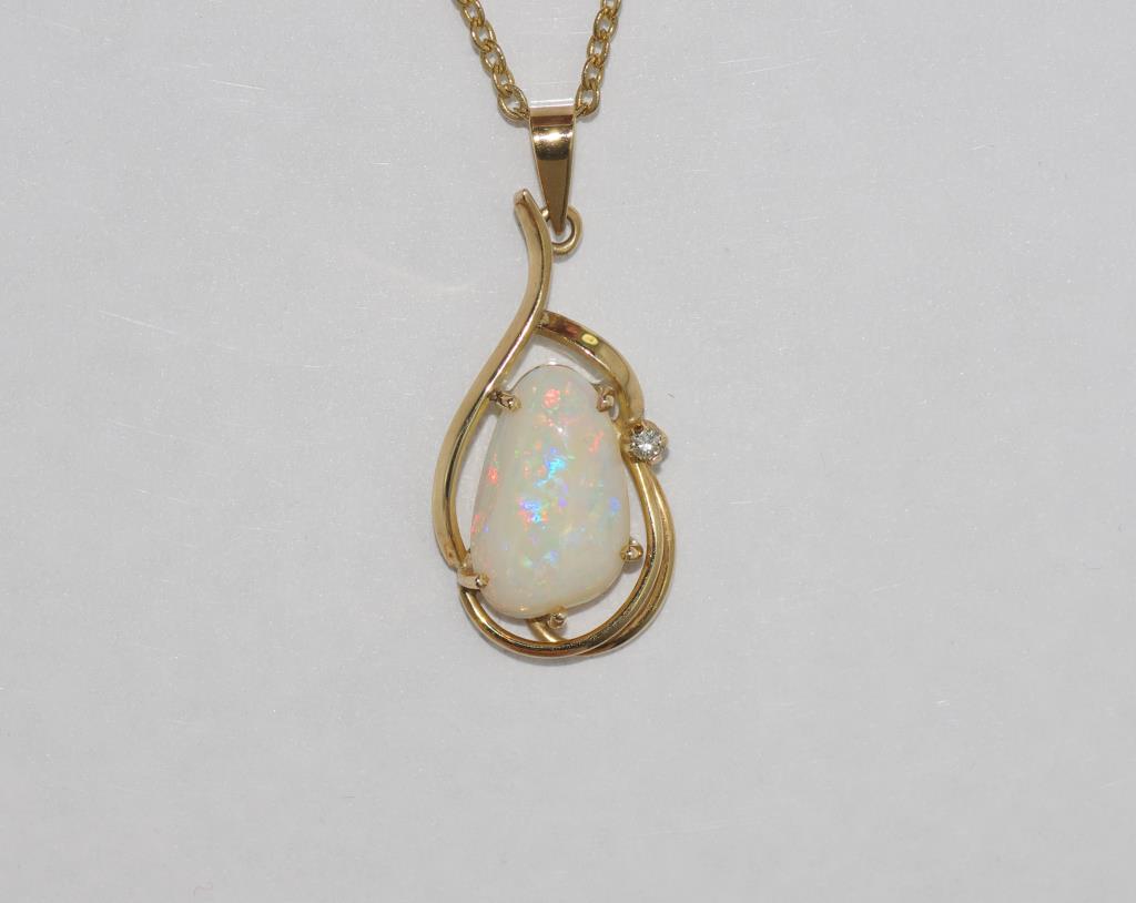 14ct gold and good colour solid opal set with diamond in surround, on gilt metal chain