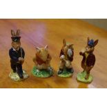 Four Royal Doulton figurines comprising three Bunnykins "Rise & Shine", "Cooling Off" & "Postman"