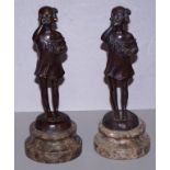 Two French bronze standing girl figurines both holding a bowl in one hand, signed to rear base, on