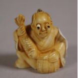 Antique Japanese ivory netsuke depicting a man holding a fish, signed to base, 4cm high approx. NB