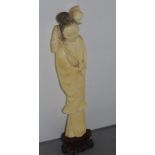 Antique carved ivory Chinese figure of a lady with lotus flower and leaf on stand, approx 26cm