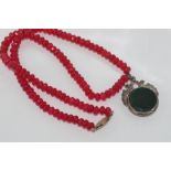 Hallmarked silver double sided fob pendant on facetted red stone necklace