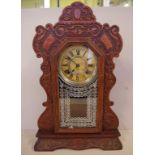 Antique Ansonia cottage clock with eight day striking movement, in ornate oak case, key and pendulum