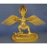 Tibetan gilt metal garuda bird figure standing on a prostrate mythological figure, (a deity of