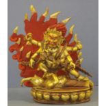 Tibetan gilt metal figure of Yama (god of death), Yama striding over a prostrate mythical beast,