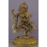 Tibetan gilt metal Yama figure astride a prostrate figure, H34cm approx