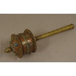 Tibetan mani prayer wheel with brass spiral handle and applied decoration to top, 29cm long