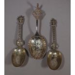 Three ornately decorated silver serving spoons