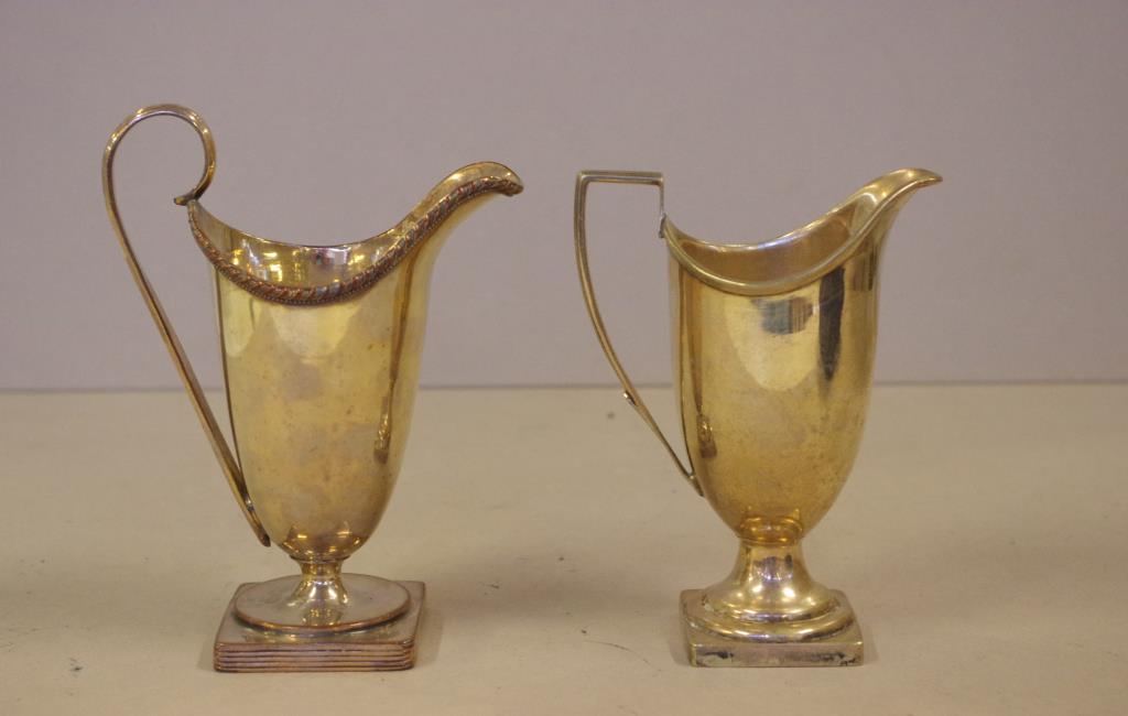 Two Victorian silver plated helmet creamers