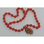 Silver pendant with coral coloured glass beads