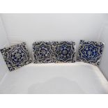 A collection of four Qajar cobalt blue tiles with central flower in star motif with scrolling