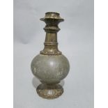 A C12th Islamic bottle of bulbous form in copper on flared bronze base, with repeating floral