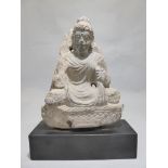 An early Ghandaran seated figure of a Buddha in meditative crossed legged position, in carved schist