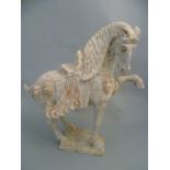 A Chinese Tang Dynasty pottery figure of a Dancing Horse on platform base with some original pigment