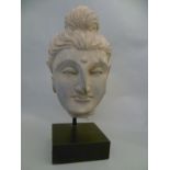 A Gandaran schist Buddha head, the hair pulled back in to a top knot, on mounted block H24cm W13cm