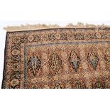 A Tabriz carpet:, of garden design, the panelled field with varying shades of brown,