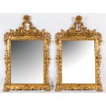 A pair of carved giltwood wall mirrors:, with pierced flowerhead, foliate and scroll crestings,