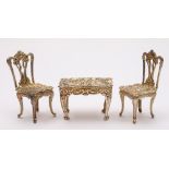 A collection of silver miniature tables and chairs,