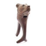 A Black Forest carved hardwood nutcracker: in the form of a bear's head, with inset glass eyes,