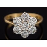 An 18ct gold and diamond seven stone circular cluster ring: with circular brilliant-cut diamonds