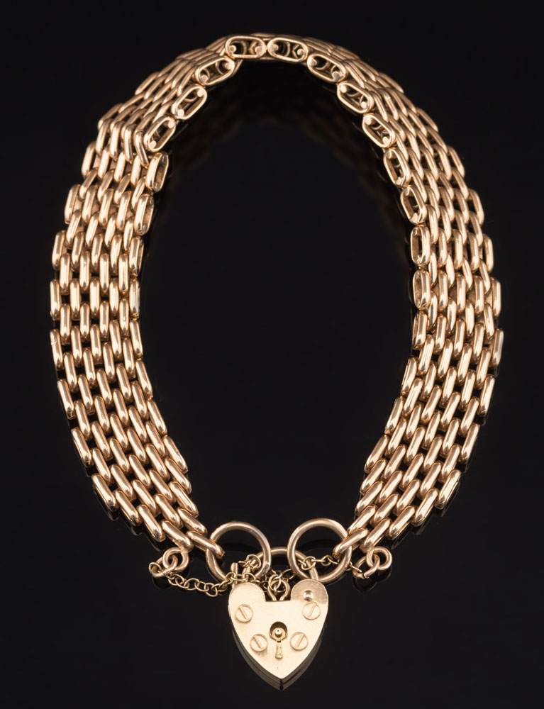 A 9ct gold bracelet: with heart shaped pad-lock clasp and safety chain, 33gms gross weight.