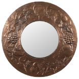 An Arts and Crafts influence circular copper wall mirror: the circular mirror plate enclosed in an