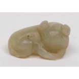 A Chinese carved jade figure of a reclining beast: the stone of celadon colour, 5cm. long.