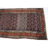 A Caucasian rug:, the indigo and pastel blue field with an all over design of flowering plants,